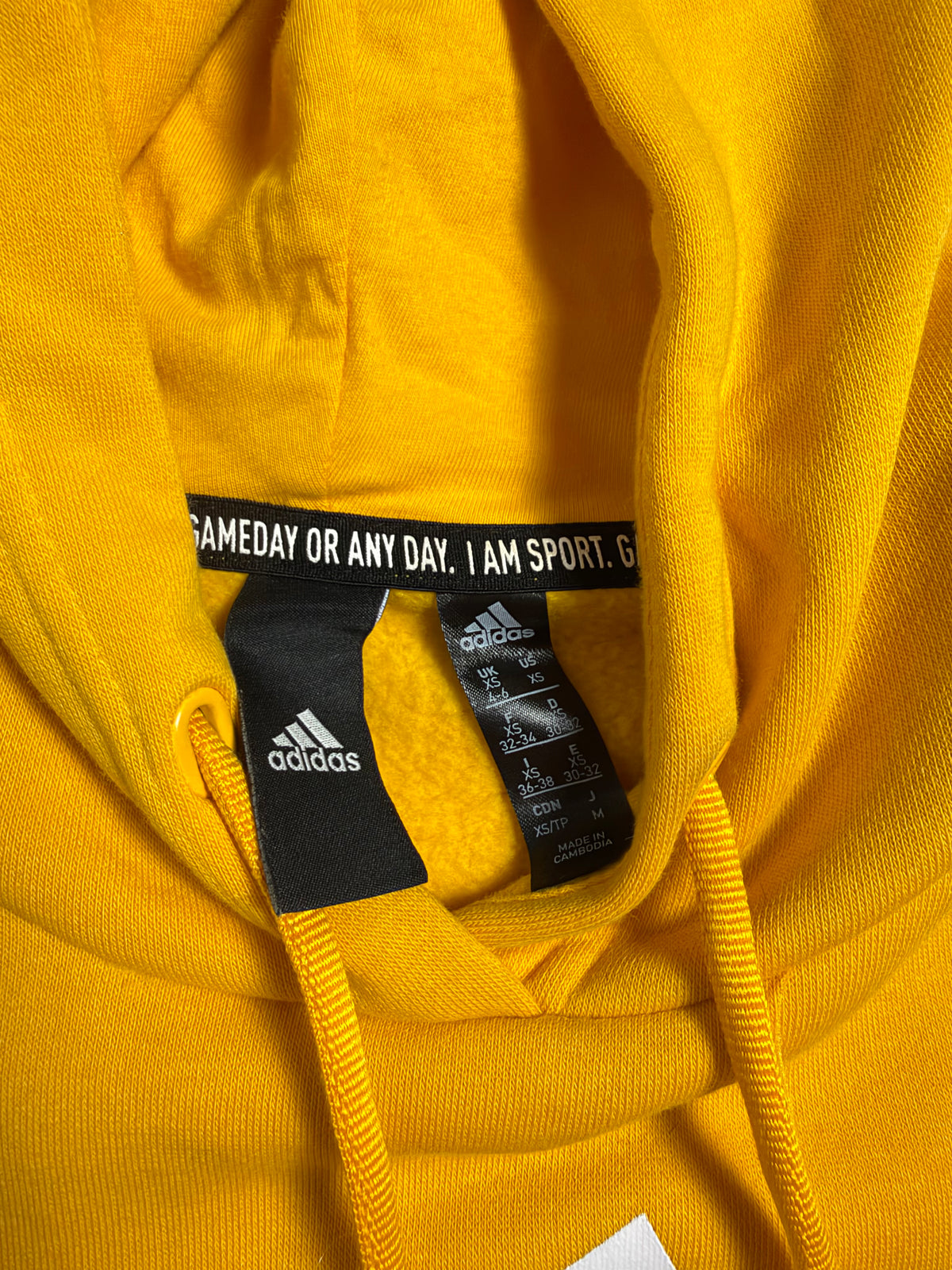 Dettaglio etichetta interna adidas al collo con taglia XS