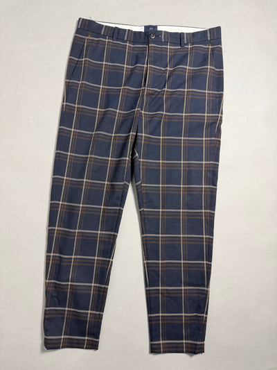 Pantaloni da uomo a quadri tartan blu e marrone distesi sul piano