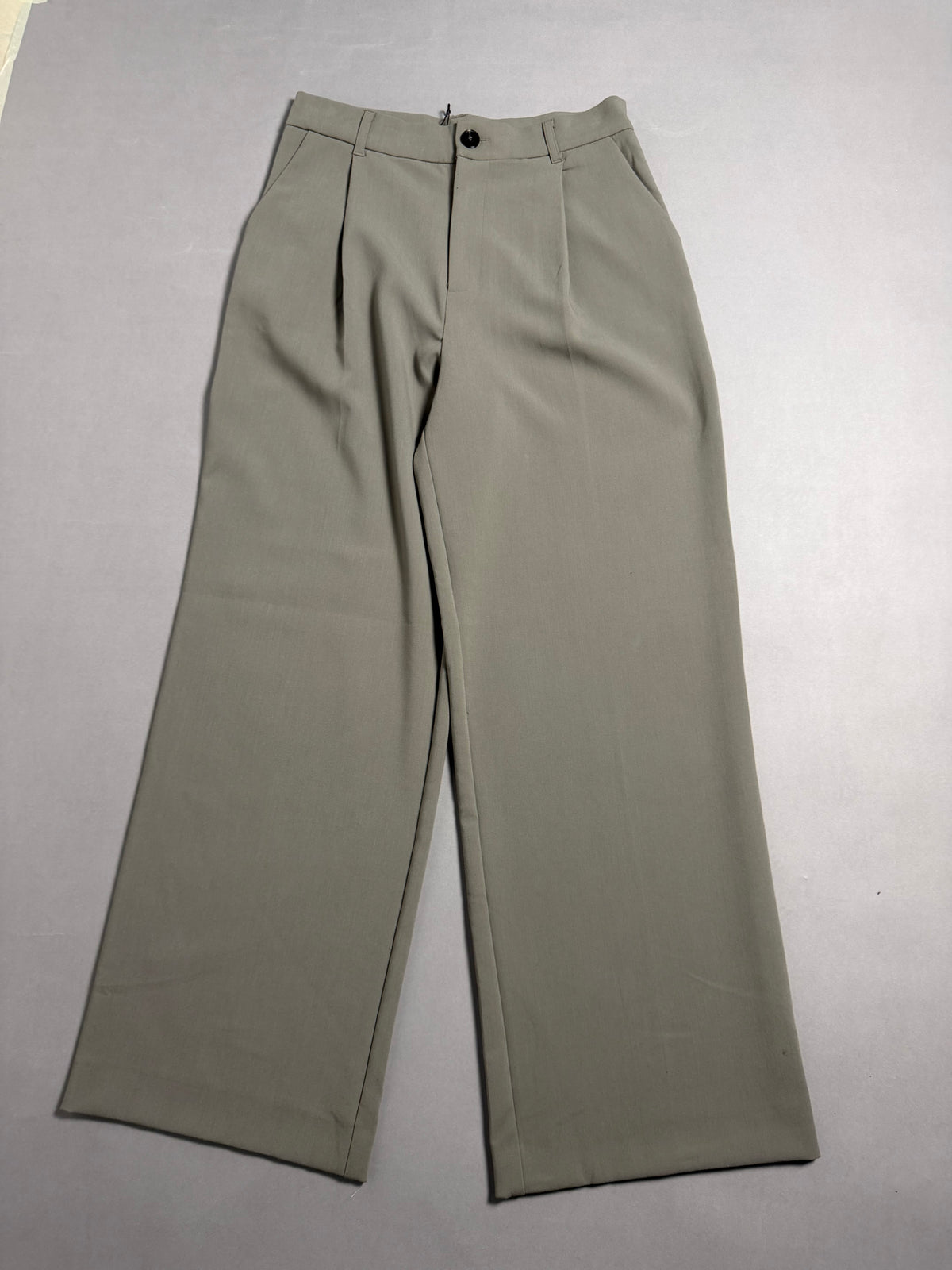 Pantaloni ampi Zara verde salvia stesi sul piano