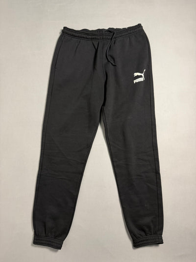 Pantaloni tuta jogger Puma neri con logo bianco stampato su fondo chiaro