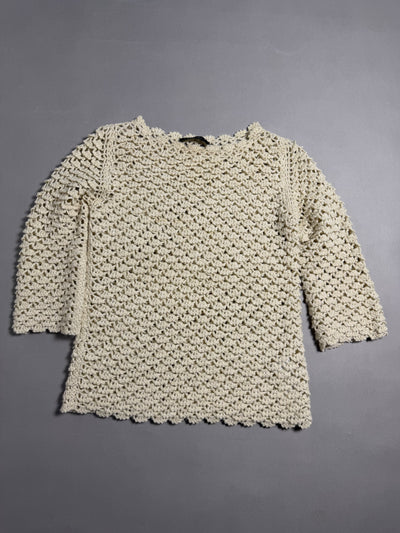 Maglione traforato Twinset color panna steso su sfondo grigio