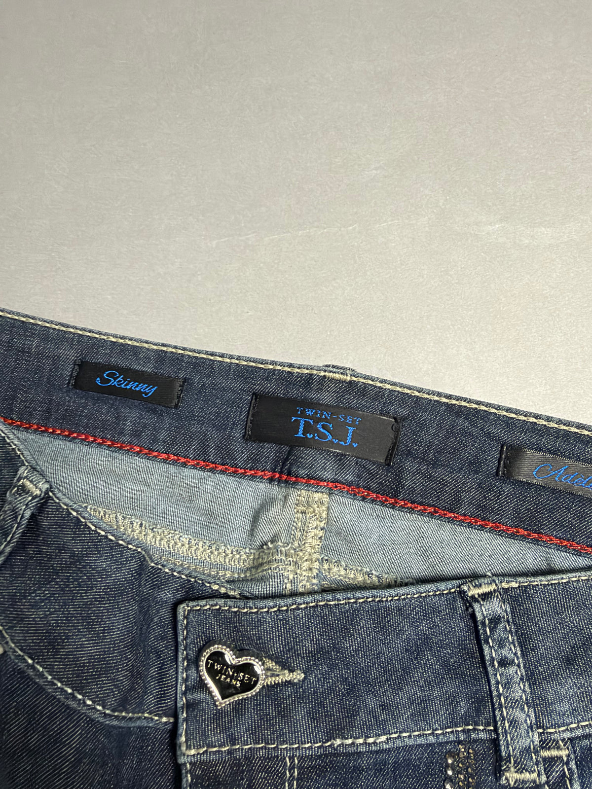 Dettaglio interno vita con etichette Twin-Set T.S.J. Skinny e placchetta a cuore sulla tasca