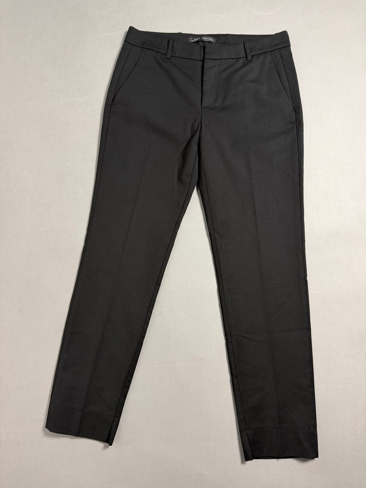 Pantaloni neri eleganti Zara Woman distesi su superficie neutra