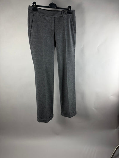 Pantaloni sartoriali da donna grigi con piega centrale e risvolto, vista frontale su gruccia