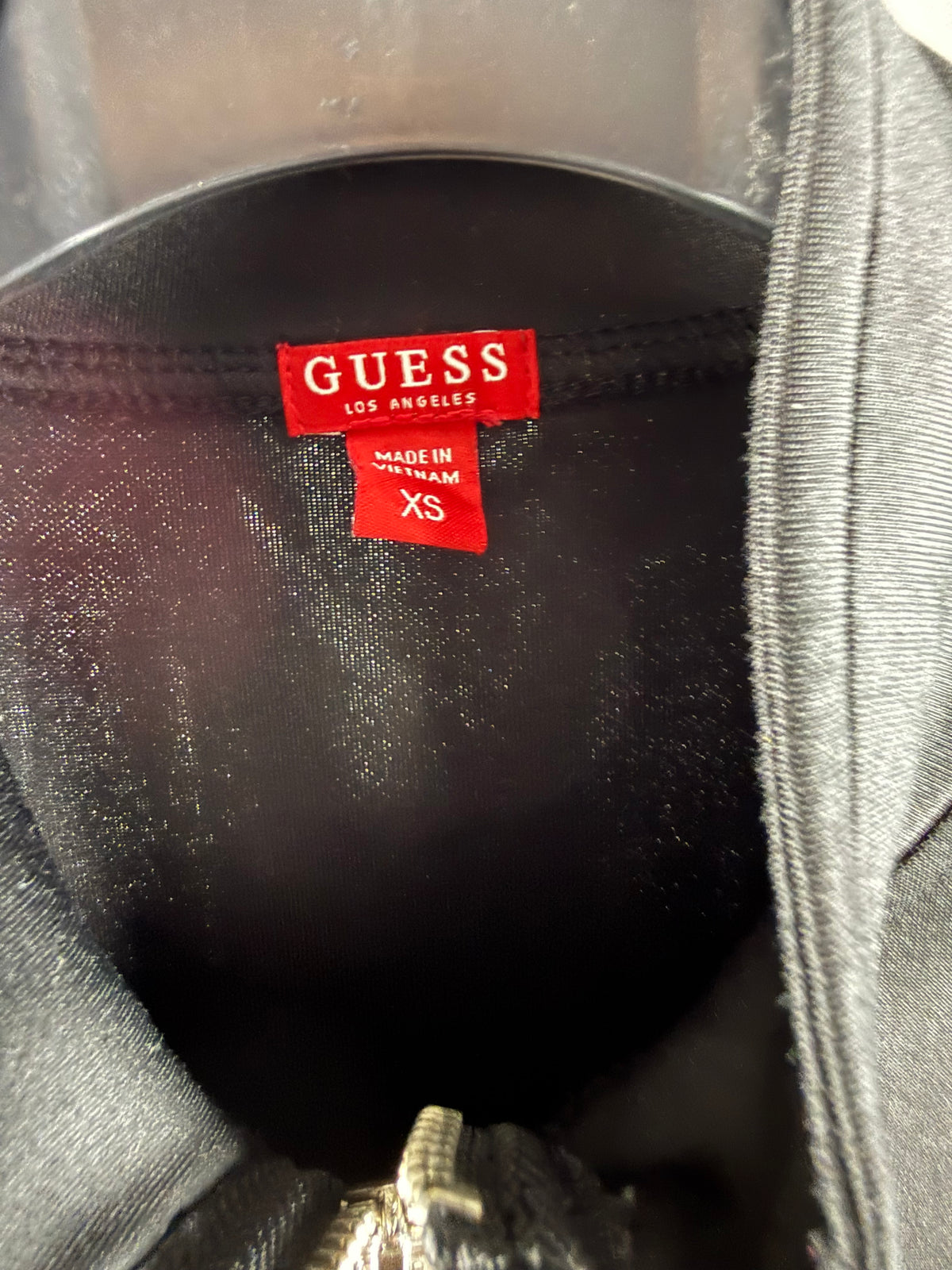 Dettaglio etichetta interna rossa GUESS con taglia XS