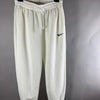 Vista frontale di pantaloni tuta Nike panna con logo Swoosh nero