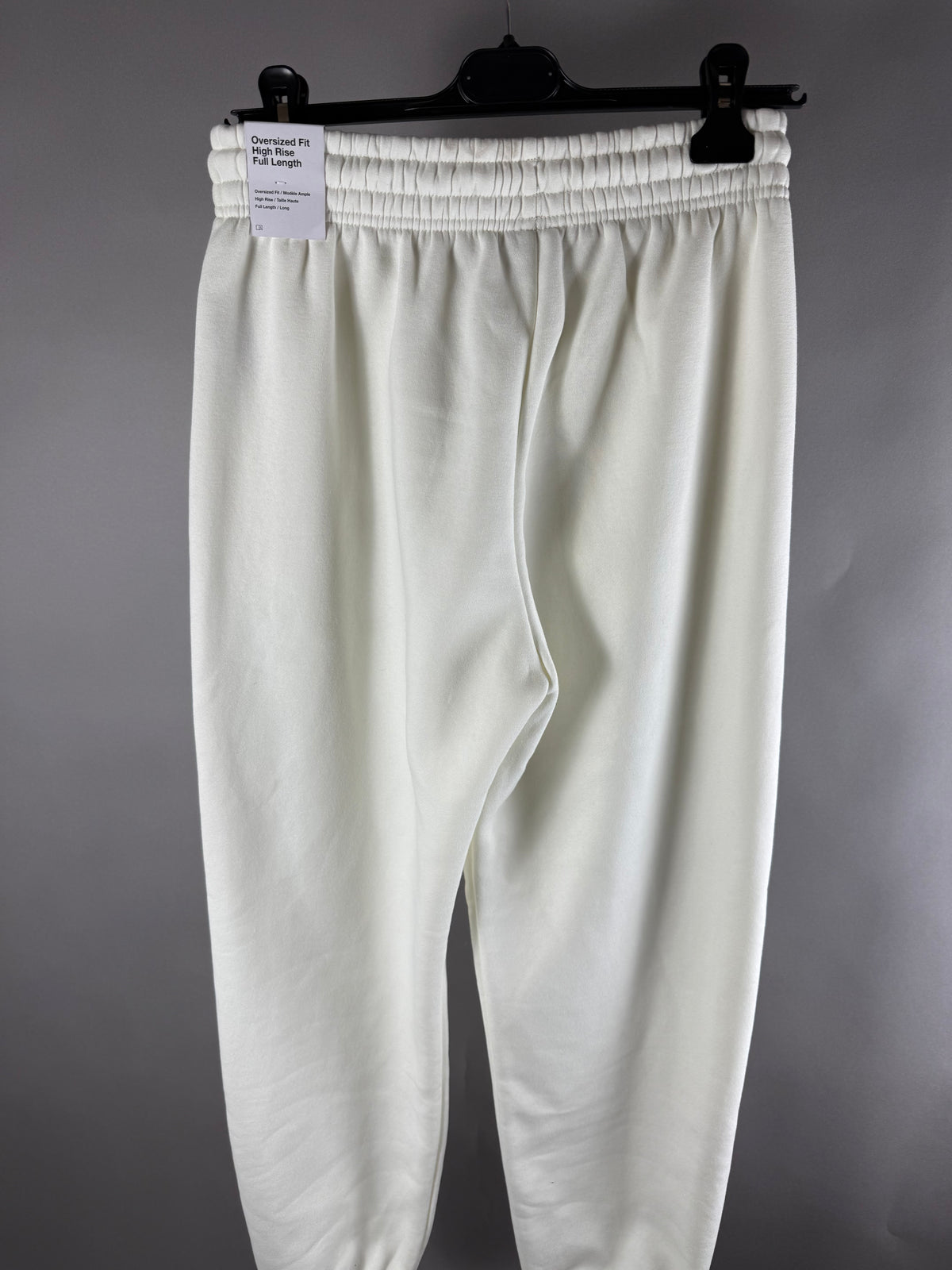 Vista posteriore dei pantaloni tuta Nike panna con cartellino fit oversized