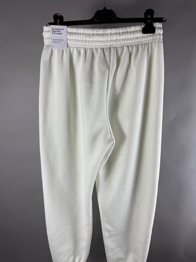 Vista posteriore dei pantaloni tuta Nike panna con cartellino fit oversized