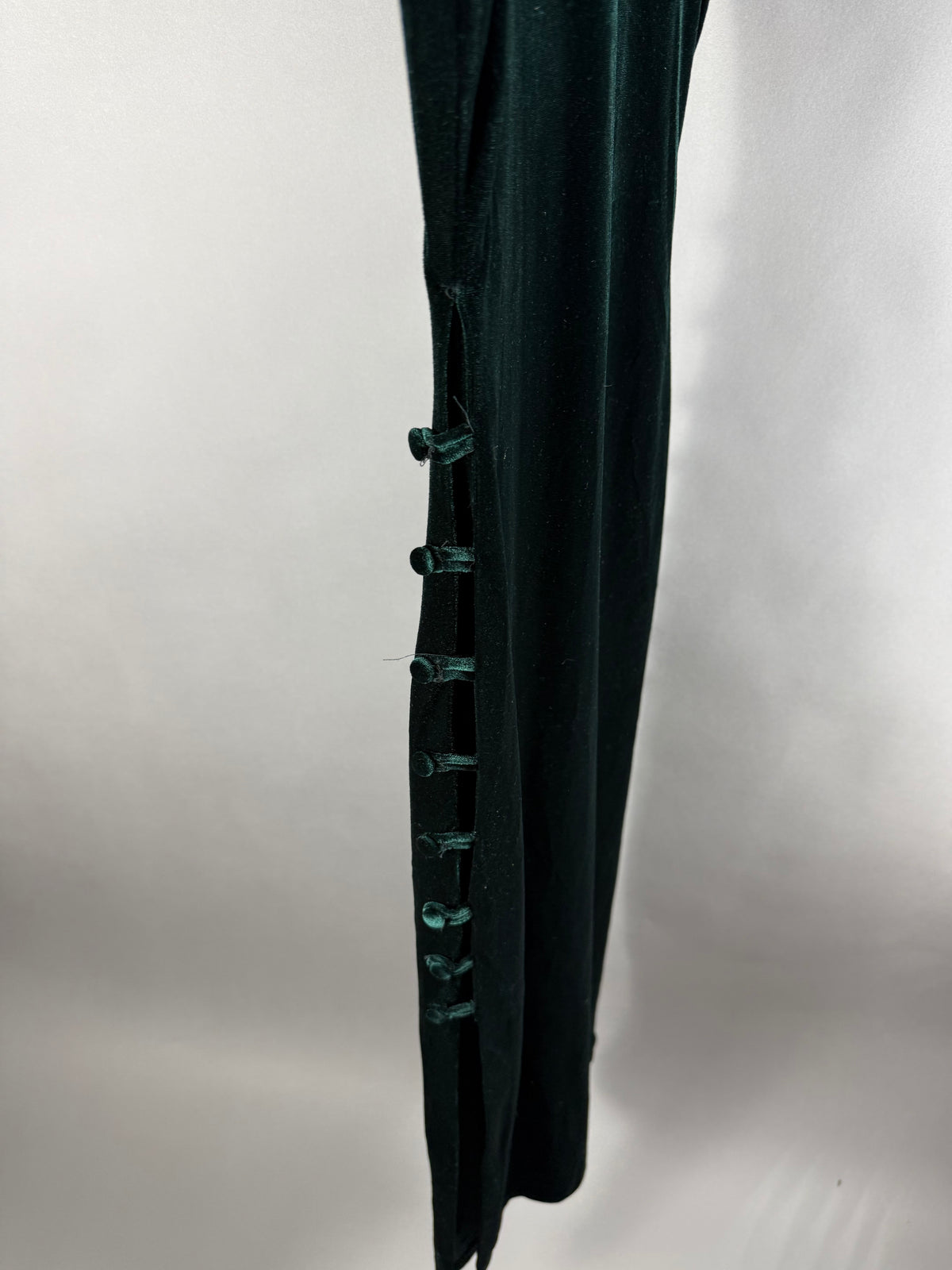 Dettaglio laterale dell’abito Zara verde scuro con bottoni rivestiti e spacco