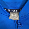Dettaglio etichetta Puma interna e tirazip della felpa blu