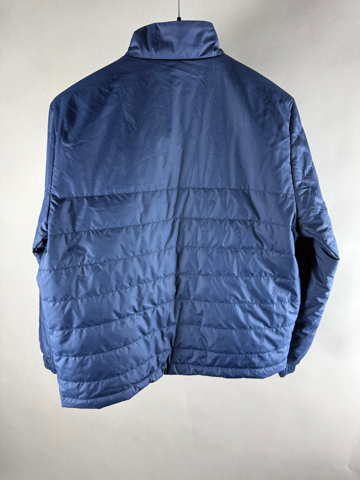 Retro della giacca imbottita blu con trapuntatura e collo alto