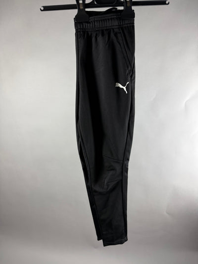 Vista frontale dei pantaloni sportivi Puma neri con logo bianco sulla gamba