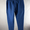 Vista posteriore dei pantaloni jogger blu navy con piccolo segno sulla gamba sinistra